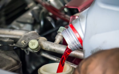 Tech putting transmission fluid into an engine